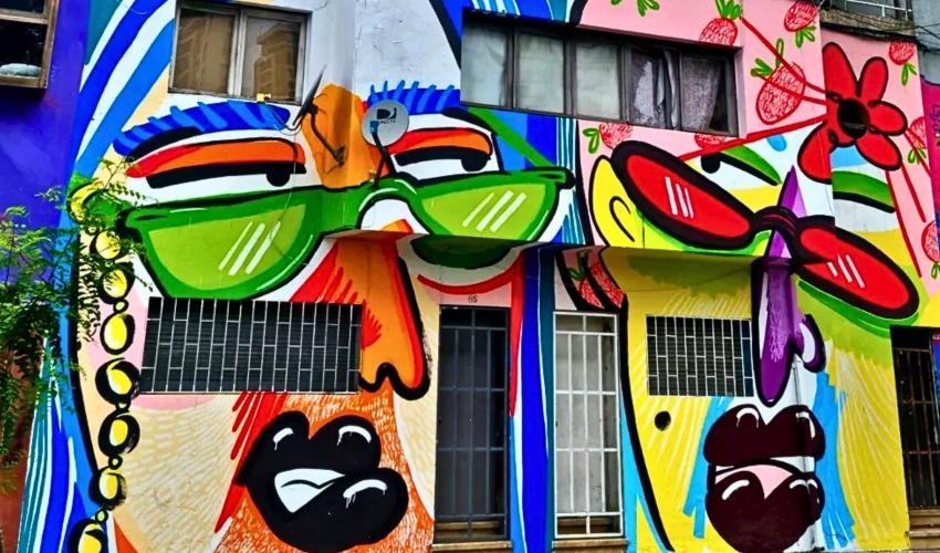 mural colorido con dos rostros de personajes mirándose entre si en una calle del barrio bellavista