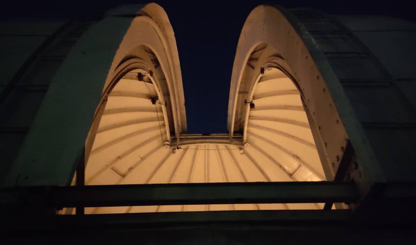 Fotografía nocturna del exterior del domo del Observatorio con la rendija abierta