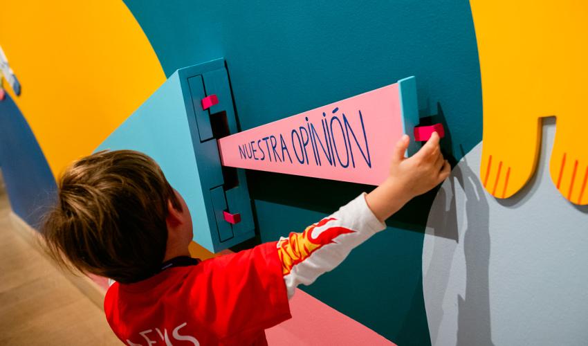 niño con una pancarta que dice: "Nuestra opinión"